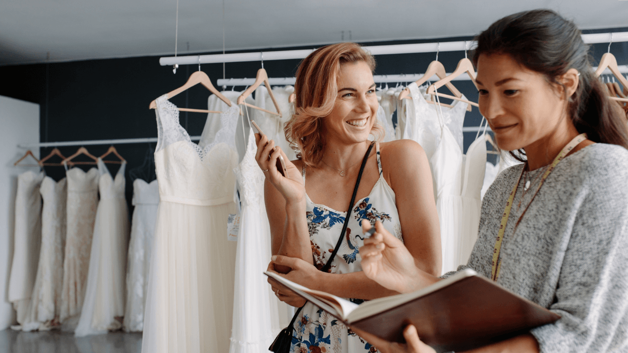 Bridal Wardrobe consultant with wedding dresses in boutique