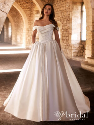 Bride wearing the GAVIANA Étoile Mikado ballgown wedding dress with a scoop neckline, off-the-shoulder sleeves, princess-boned corset bodice, basque waist and cathedral train.