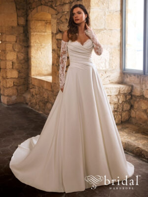 Bride wearing the GRACELLE Étoile ballgown wedding dress with a sweetheart neckline, detachable long sleeves, ruched bodice, basque waist and sweeping royal train.