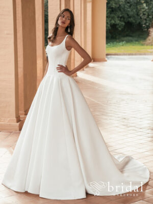 Bride wearing the ULANDRA Blue by Enzoani ballgown wedding dress with a scoop neckline, sleeveless straps, structured princess bodice and sweeping royal train