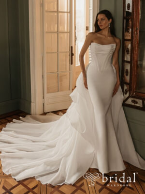 Bride wearing the HEIDI Élysée ballgown wedding dress with a straight strapless neckline, princess-boned bodice, basque waist, detachable ruched organza overskirt and cathedral train.