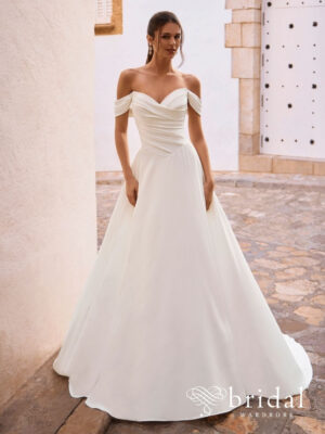 Bride wearing the FIONNA A-line wedding dress from the Love collection with a sweetheart neckline, off-the-shoulder sleeves, ruched bodice, basque waist and chapel train