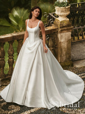 Bride wearing the WISTERIA by Enzoani ballgown wedding dress with a scoop neckline, wide straps, asymmetric ruching, hidden skirt slit and cathedral-length train.