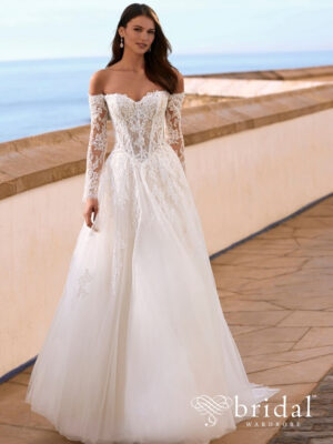 Bride wearing the FAIZA A-line wedding dress from the Love collection with a sweetheart neckline, removable long sleeves, basque waist and cathedral train.