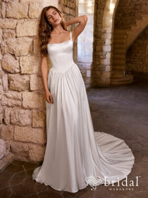 Bride wearing the GABBES Étoile A-line wedding dress with a scooped square neckline, sleeveless straps, princess-boned bodice, basque waist and chapel train.