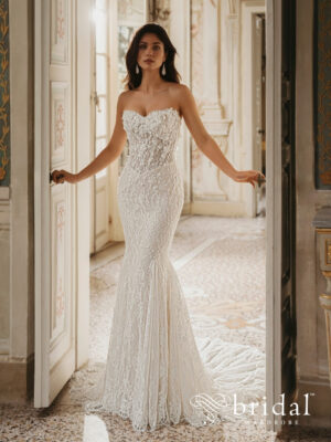 Bride wearing the WINNIE by Enzoani trumpet wedding dress with a strapless sweetheart neckline, basque waist, delicate 3D floral embellishments and a sweeping court train.