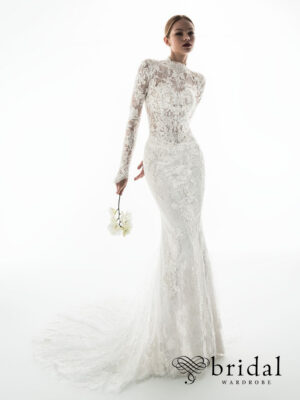 Bride wearing the GAMIRA Privé column wedding dress with a high neckline, long sleeves, princess-boned bodice, basque waist and sweeping cathedral train.