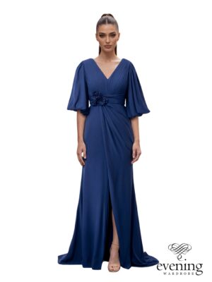 Woman wearing Style 1222, a Twilight Blue chiffon evening gown with deep V-neckline, balloon sleeves, floral waist detail, leg slit and V-back.
